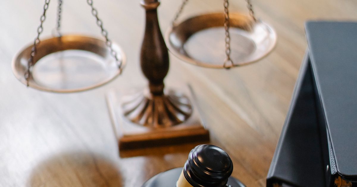 Balanza de la justicia y mazo de juez sobre un escritorio de madera
